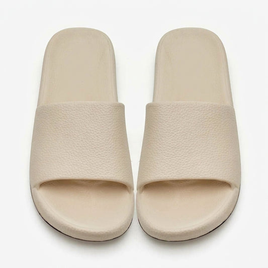 Women's cream textured comfort slides on white background